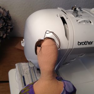 Hand stitching the bangs.