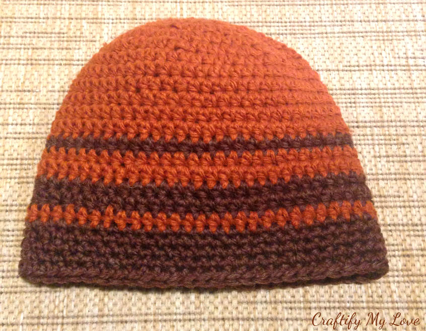 Crocheted men's hat in brown and rust stripes.