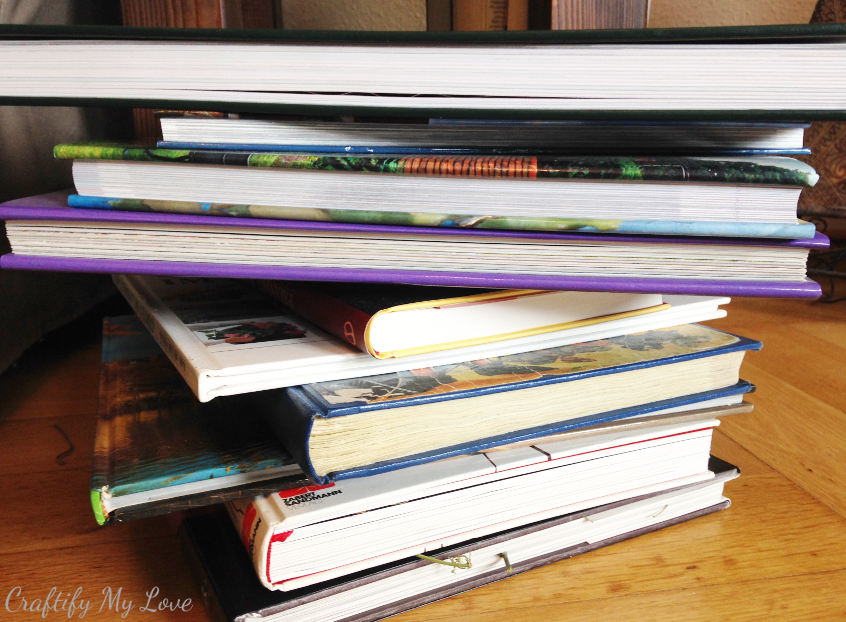 applying pressure to pressed flowers with a lot of books