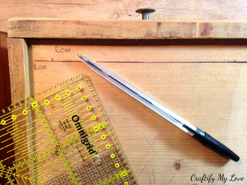 measuring and marking the spot for hangers for upcycled drawer shelf