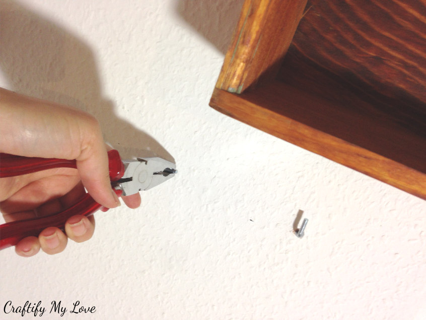 screwing hooks into wall for DIY decor storage project