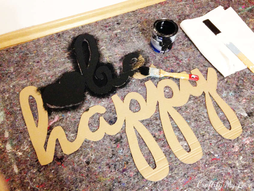 painting recycled cardboard cut-out sign with black chalkpaint