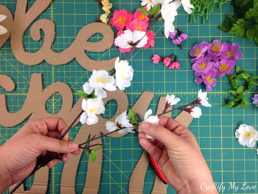 preparing the faux flowers for DIY motivational sign be happy