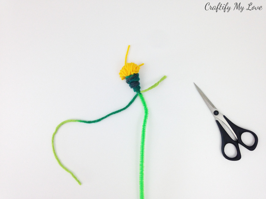 fasten off the green yarn by making a tight knot around your wobbly flower stem