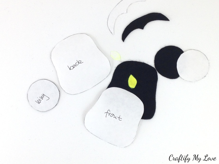 peel freezer paper off of cut out penguin elements for DIY felt bookmark