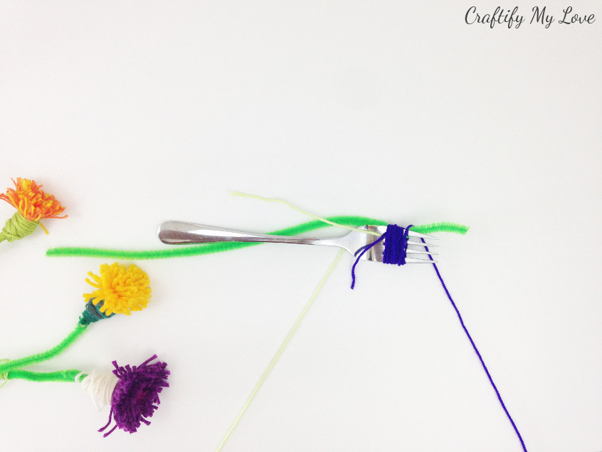 wrap your yarn around the fork to create a tassel flower