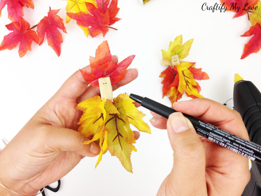 adding a smiling face to a fun and easy garden fairy DIY using a thin felt tip liner