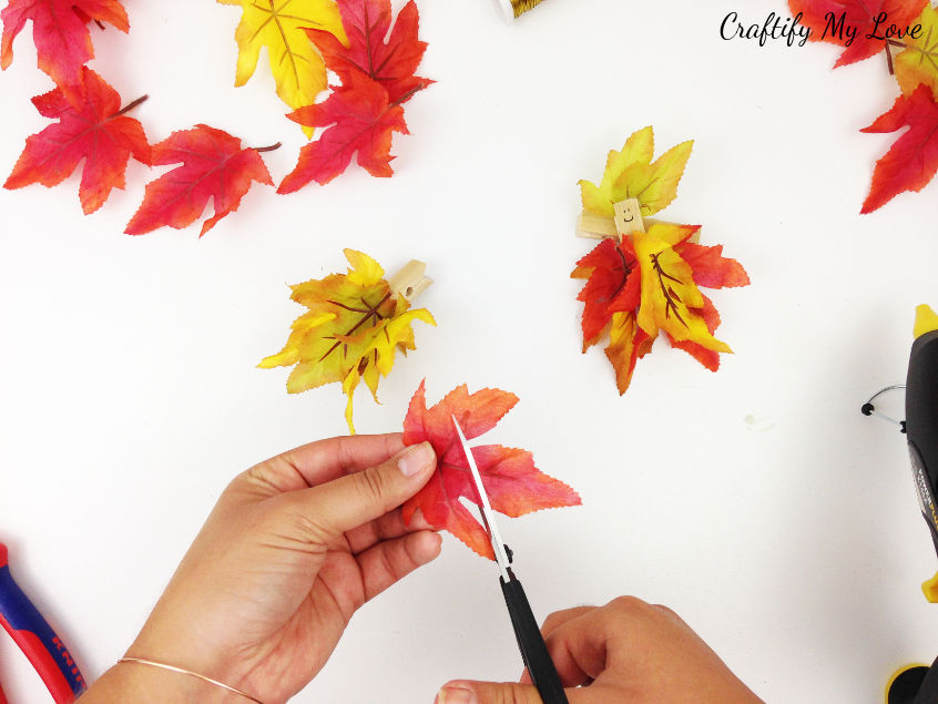 cutting silk autumn leaf to size to create a darling fall fairy hat