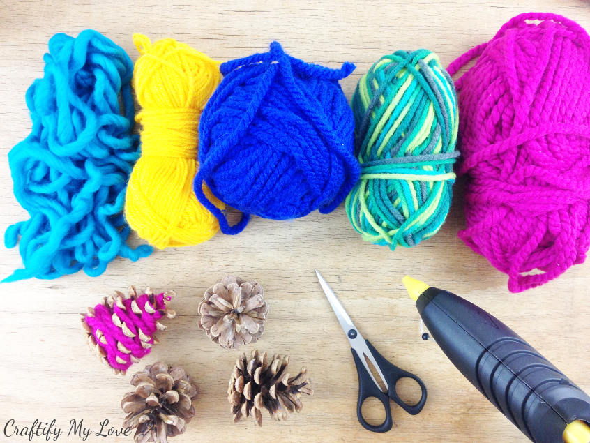 supplies for decorative hygge mini Christmas trees are yarn scraps and pine cones