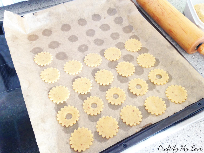 Making the same amount of cooky bases and covers. Place raw the cut out cookies on a baking try covered with paper