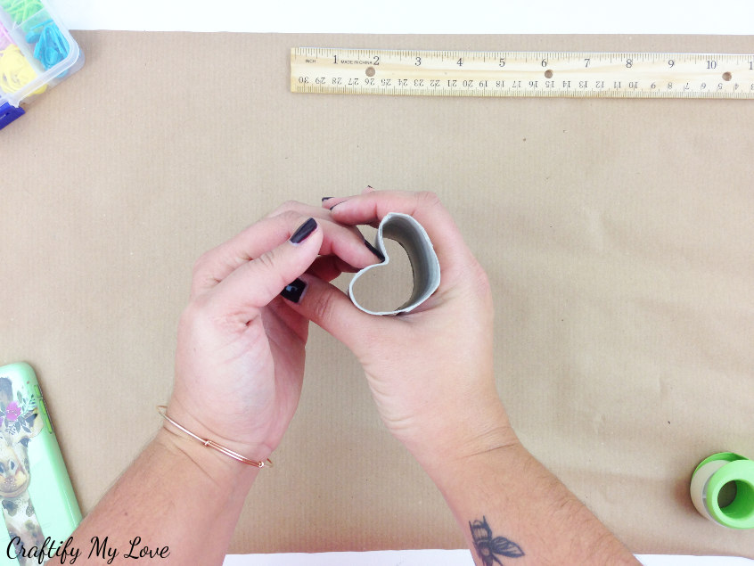 bend a toilet paper roll into a heart shape to create a custom stamp for hand printed wrapping paper that is perfectly recyclable