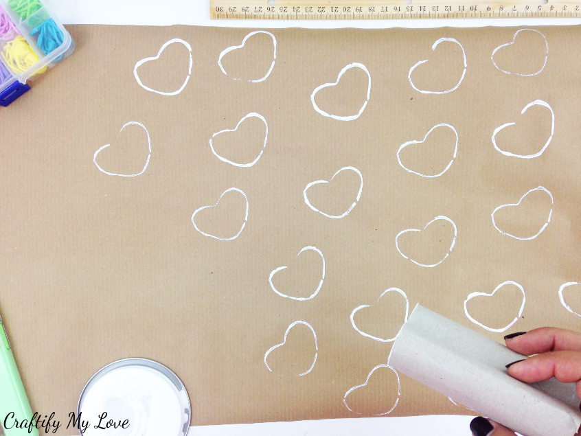 Repeatedly stamp your DIY template and create a pattern on the shipping paper to make a brown paper gift wrap idea