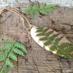 pressed and dried fern wood disc pendant for diy jewelry - a frugal dollar store craft