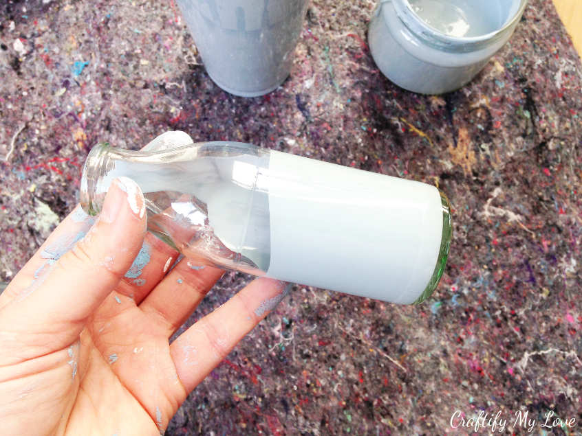pour some DIY chalk paint into an empty bottle. Twist and turn until the paint is covering your entire glass vase