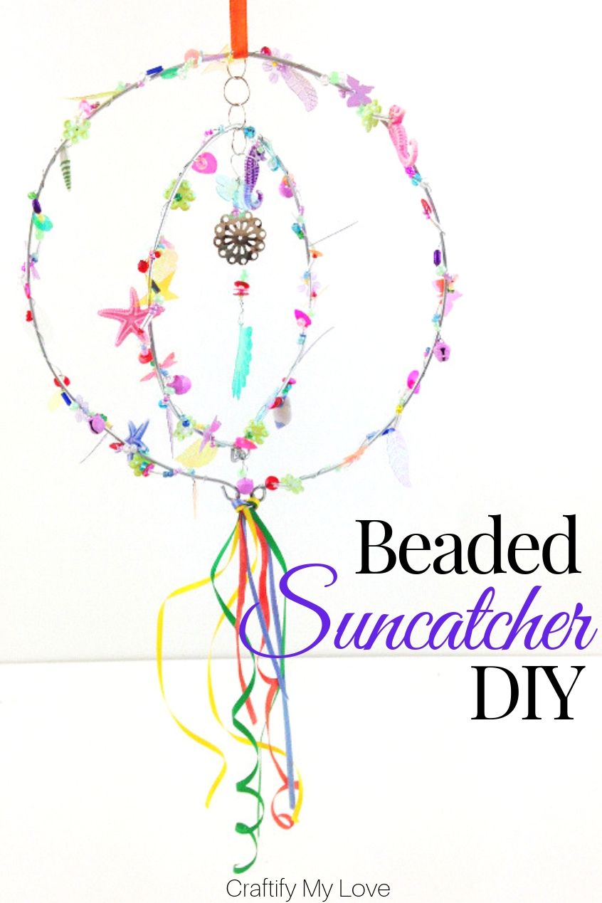Sparkly seaquined and beaded suncatcher hoop mobile to add a pop of colour to your garden. Click through for a detailed tutorial on how to make this wind spinner for little money. #craftifymylove #suncatcher #windwpinner #windchime #DIYgardendecor #summercraft #DIYhomedecor